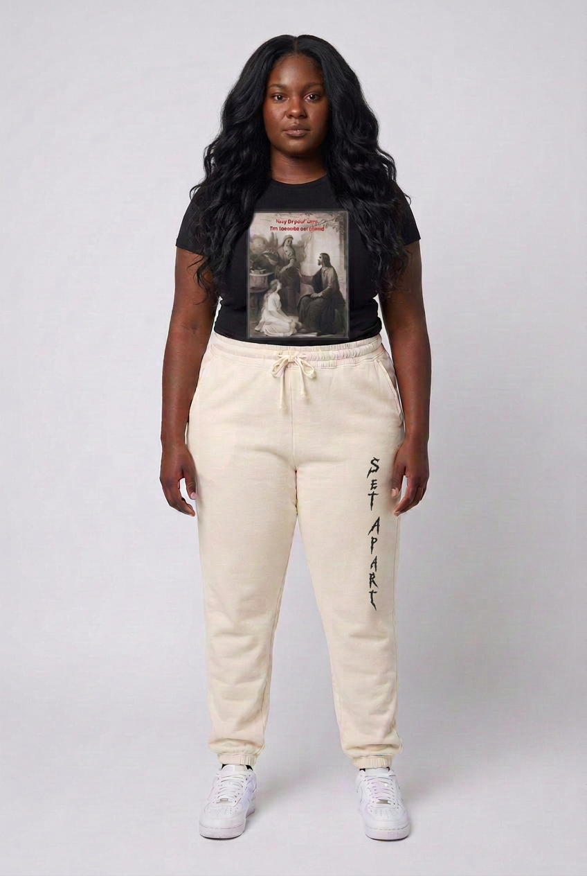 Same wavy-haired model wearing ivory joggers with the black vertical Set Apart logo